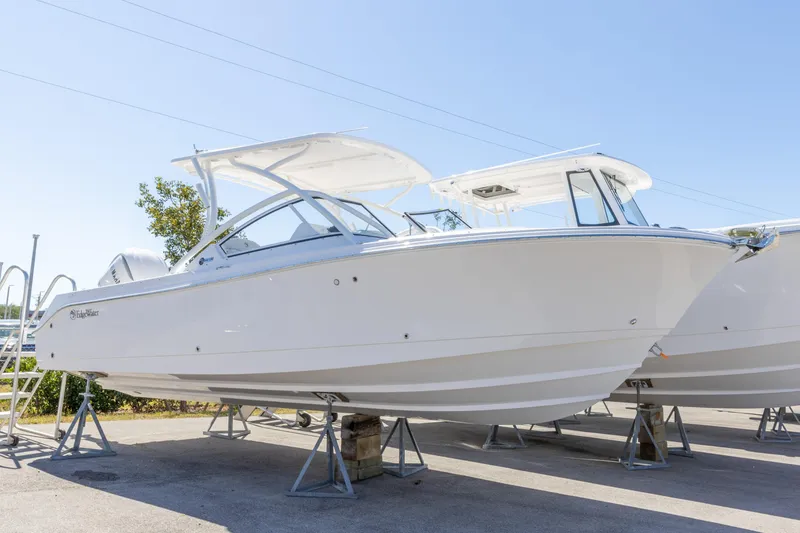 Slide: The Image of 2026 Edgewater 248CX Crossover boat displayed on stands under clear blue sky. - 16