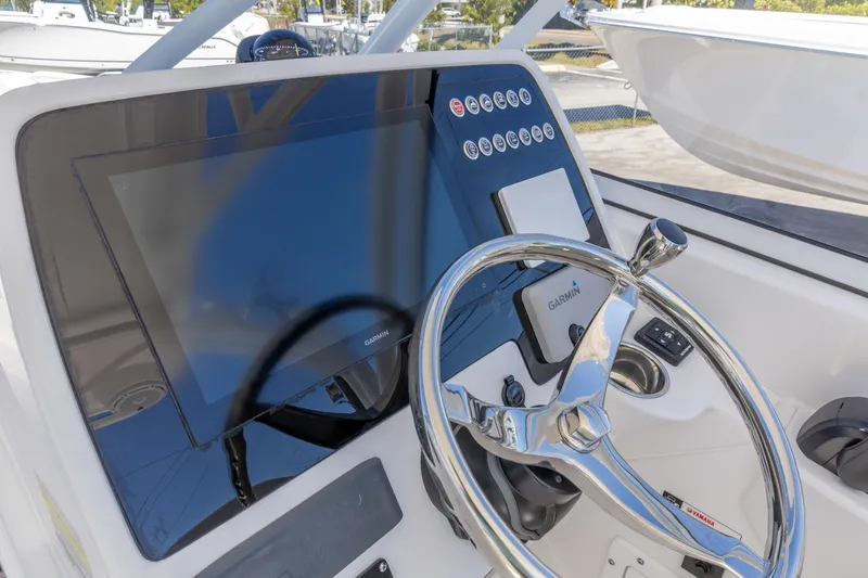 Slide: The Image of 2026 Edgewater 248CX Crossover boat dashboard with Garmin display and steering wheel. - 3