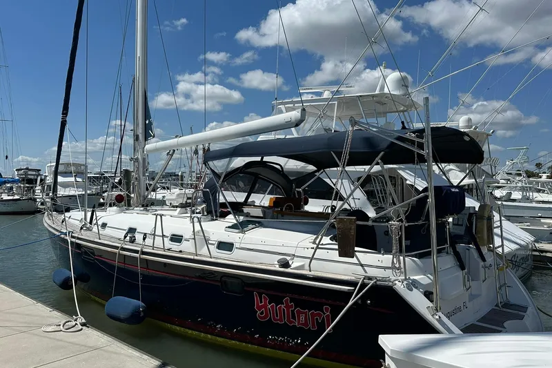 Slide: The Image of Sailboat docked at marina, Beneteau 50 model, year 2000, under a clear blue sky. - 1