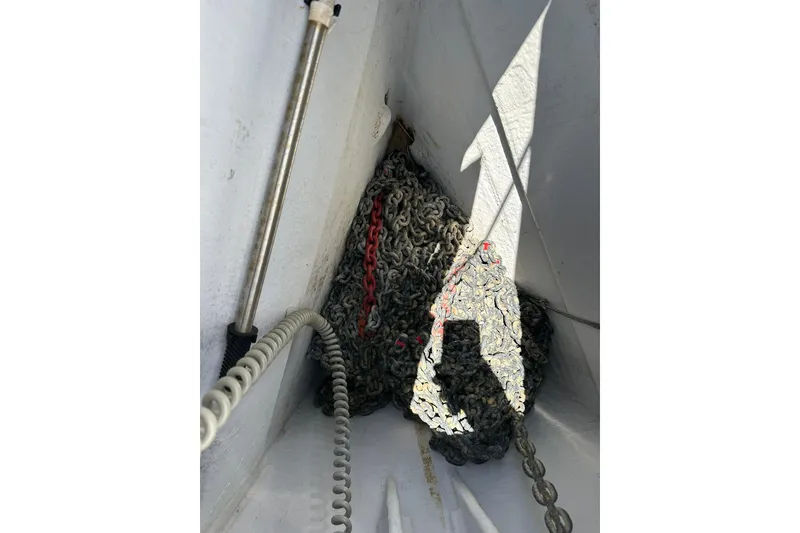 Slide: The Image of Anchor chain storage on a 2000 Beneteau 50 sailboat, featuring coiled metal chains. - 51