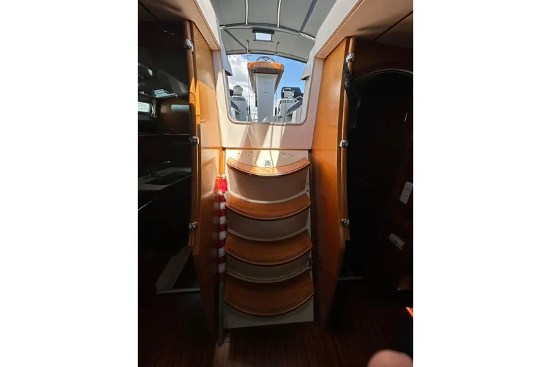 Slide: The Image of Interior view of a 2000 Beneteau 50 yacht, featuring wooden steps and a skylight. - 65