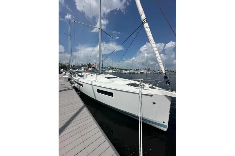 Slide: The Image of 2023 Jeanneau Sun Odyssey 490 sailboat docked at marina under blue sky. - 1