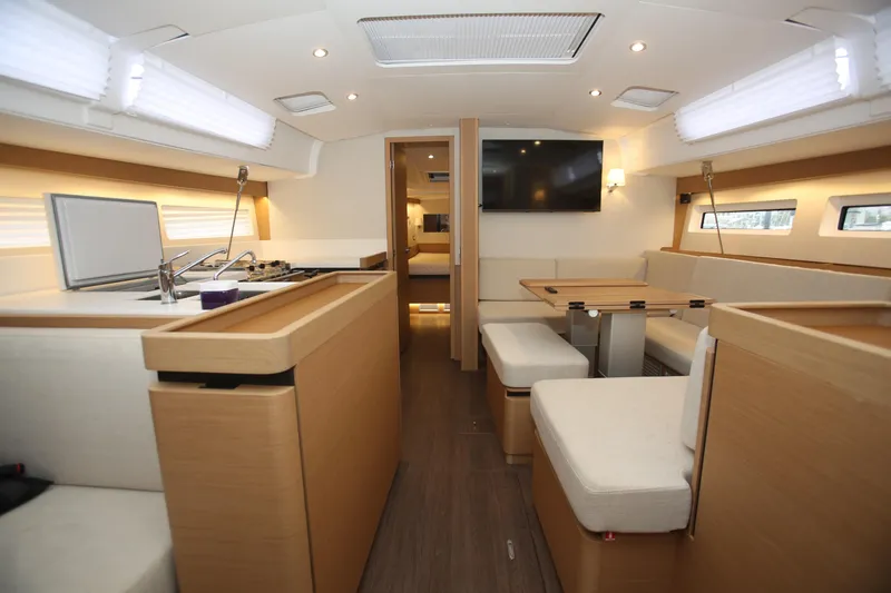 Slide: The Image of Interior of 2023 Jeanneau Sun Odyssey 490 yacht, featuring modern kitchen and seating area. - 13
