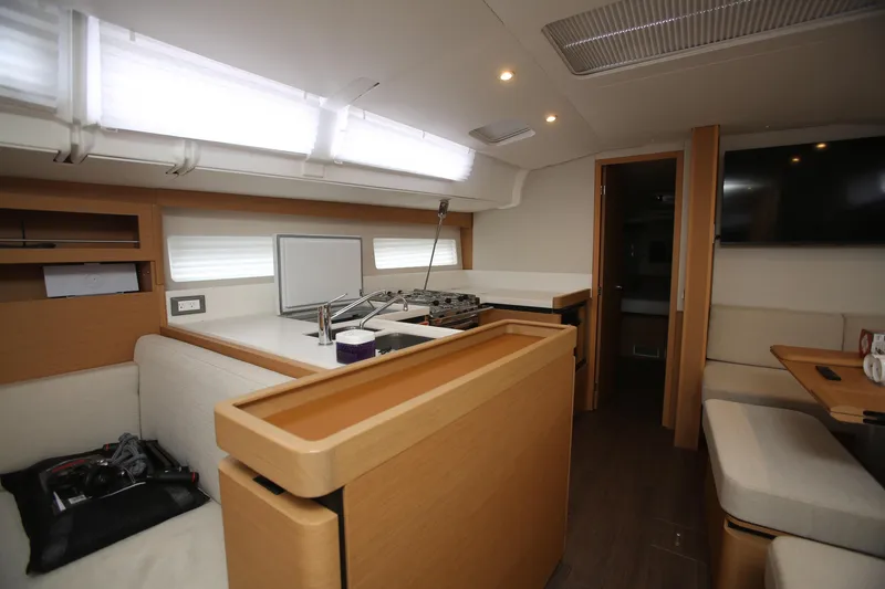 Slide: The Image of Interior of 2023 Jeanneau Sun Odyssey 490 yacht, featuring modern kitchen and seating area. - 19