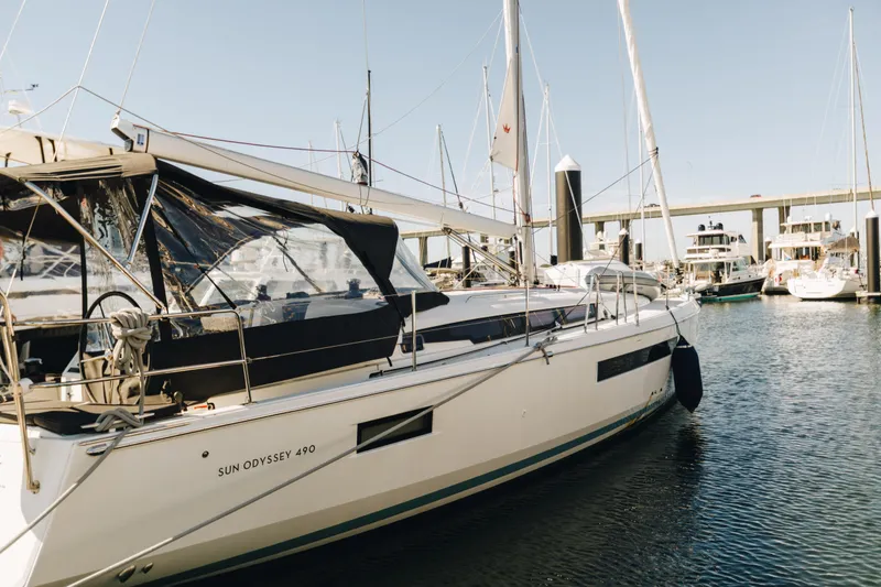 Slide: The Image of 2023 Jeanneau Sun Odyssey 490 sailboat docked in marina, clear sky background. - 2