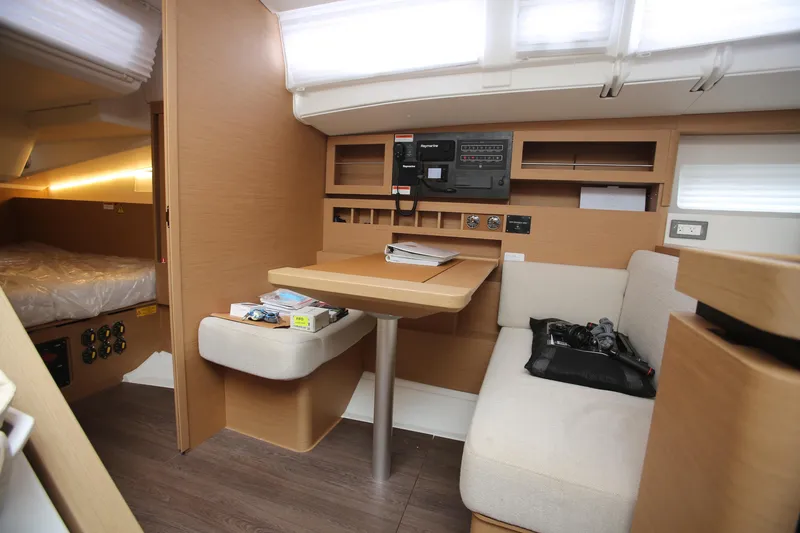 Slide: The Image of Interior of 2023 Jeanneau Sun Odyssey 490 yacht, featuring a cozy seating area and navigation panel. - 21