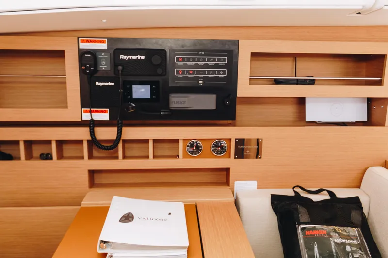 Slide: The Image of Control panel of 2023 Jeanneau Sun Odyssey 490 yacht with navigation equipment and manuals. - 23