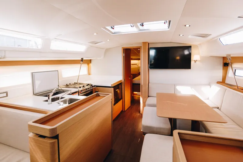 Slide: The Image of Luxurious interior of 2023 Jeanneau Sun Odyssey 490 yacht with modern kitchen and seating area. - 24