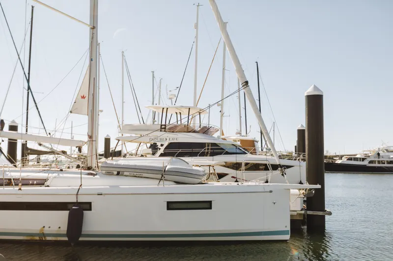 Slide: The Image of 2023 Jeanneau Sun Odyssey 490 sailboat docked in a marina under clear skies. - 3