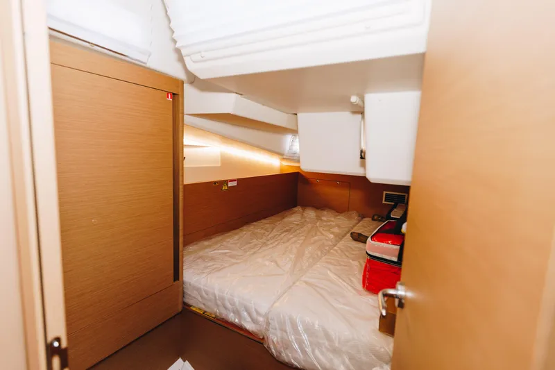 Slide: The Image of 2023 Jeanneau Sun Odyssey 490 cabin interior with cozy bed and wooden finish. - 33