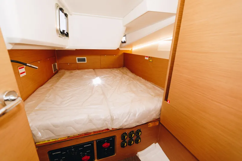 Slide: The Image of Cabin interior of 2023 Jeanneau Sun Odyssey 490 yacht, featuring a cozy bed and wooden finish. - 34
