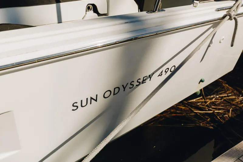 Slide: The Image of 2023 Jeanneau Sun Odyssey 490 sailboat, docked with visible name and rope. - 6