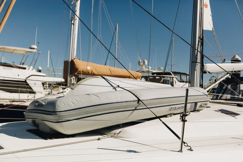 Slide: The Image of 2023 Jeanneau Sun Odyssey 490 sailboat with inflatable dinghy on deck, docked at marina. - 8