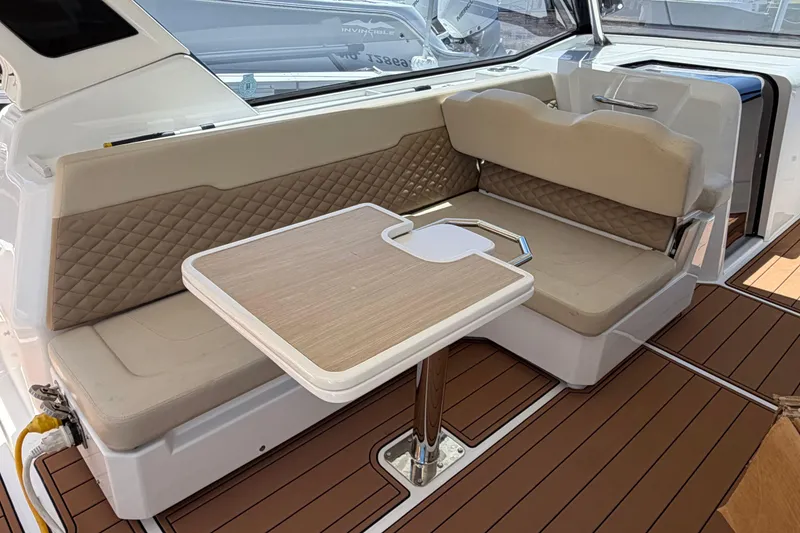 Slide: The Image of Interior of 2018 Aquila 36 Sport boat with cushioned seating and wooden table. - 5