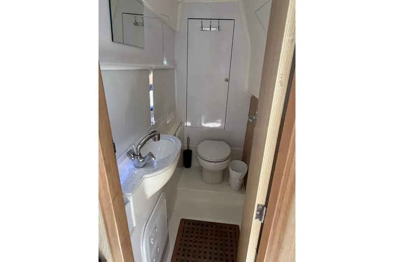 Slide: The Image of Compact bathroom in 2018 Aquila 36 Sport boat, featuring sink, toilet, and mirror. - 9