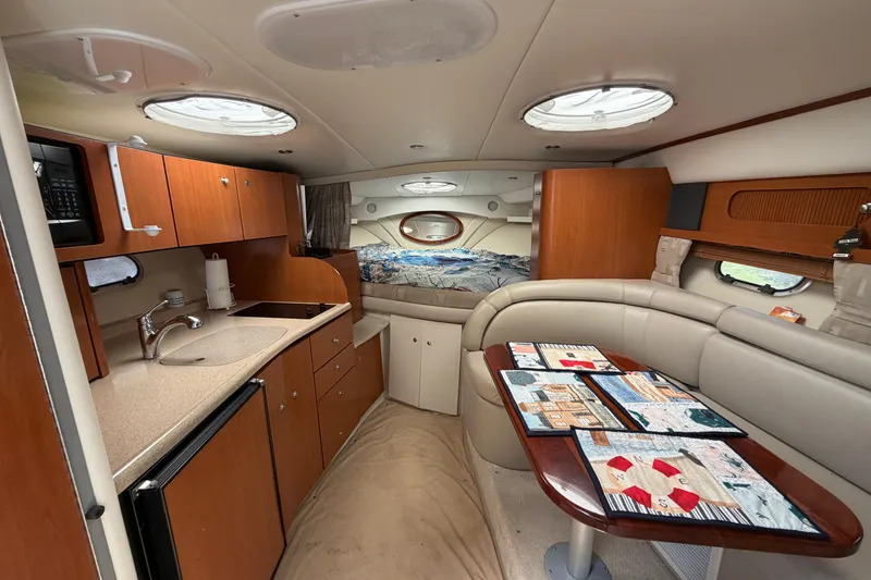 Slide: The Image of Interior of 2003 Four Winns 328 Vista boat with kitchenette and seating area. - 16