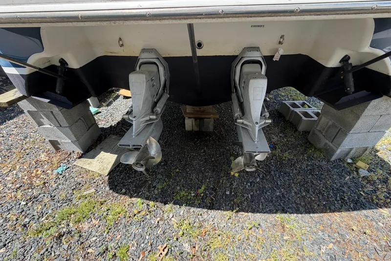 Slide: The Image of 2003 Four Winns 328 Vista boat on blocks, showing dual outboard motors. - 2