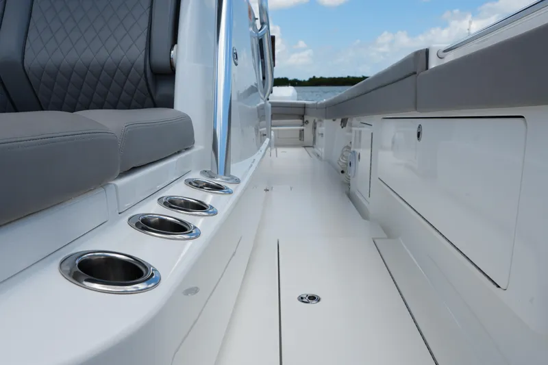 Slide: The Image of 2022 Valhalla Boatworks V-41 interior with sleek seating and cup holders, under a clear sky. - 28