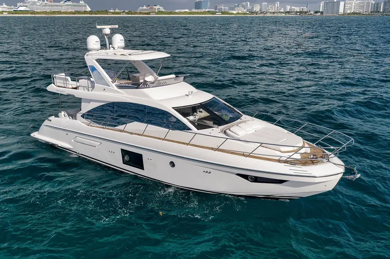 The Image of Luxurious 2019 Azimut 55 yacht cruising on open water near city skyline. - 1