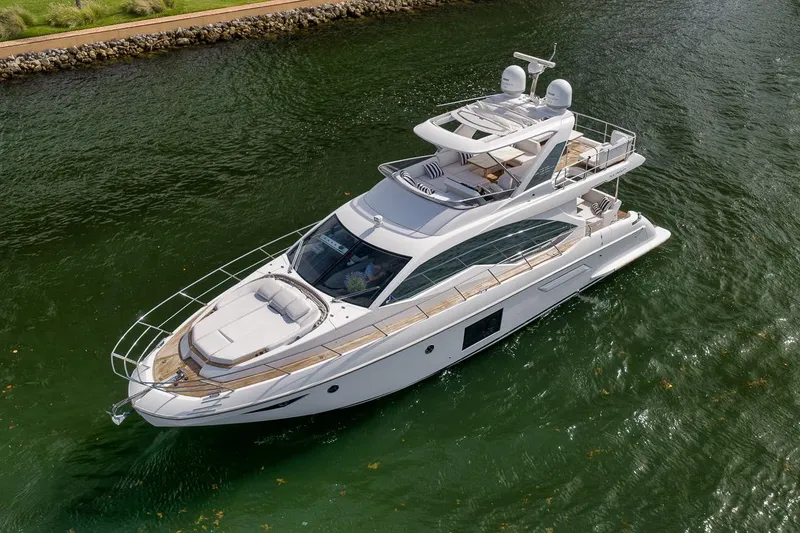 Slide: The Image of 2019 Azimut 55 yacht cruising on a calm waterway, showcasing sleek design and luxury features. - 22