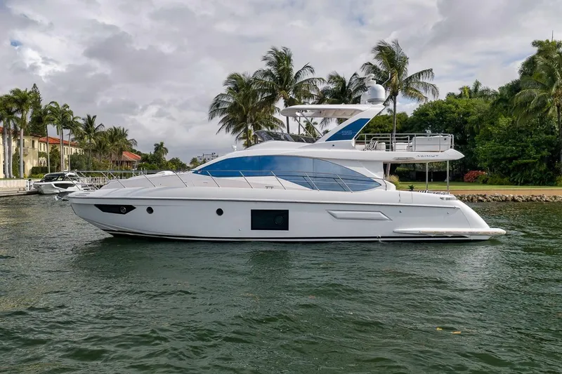 Slide: The Image of 2019 Azimut 55 yacht cruising near palm-lined waterfront homes. - 24