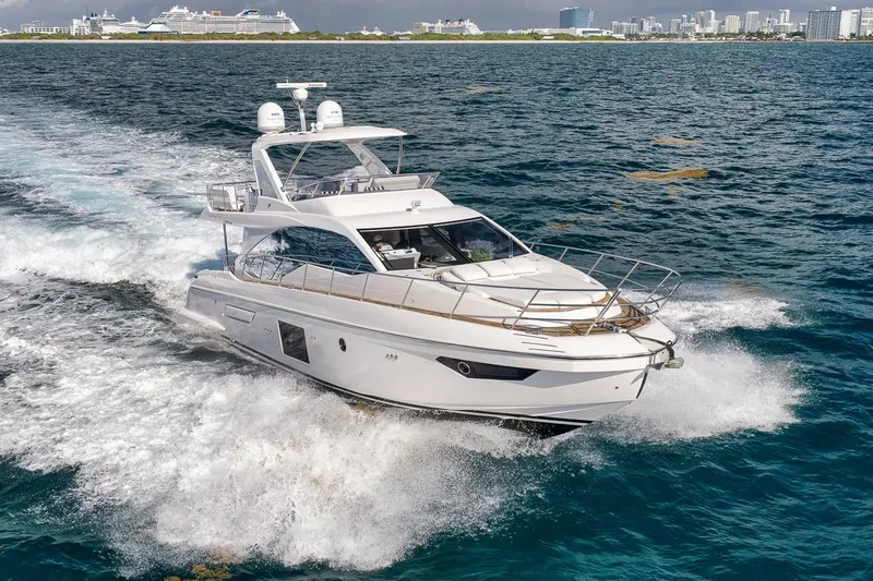 Slide: The Image of Luxury 2019 Azimut 55 yacht cruising on open water near city skyline. - 3