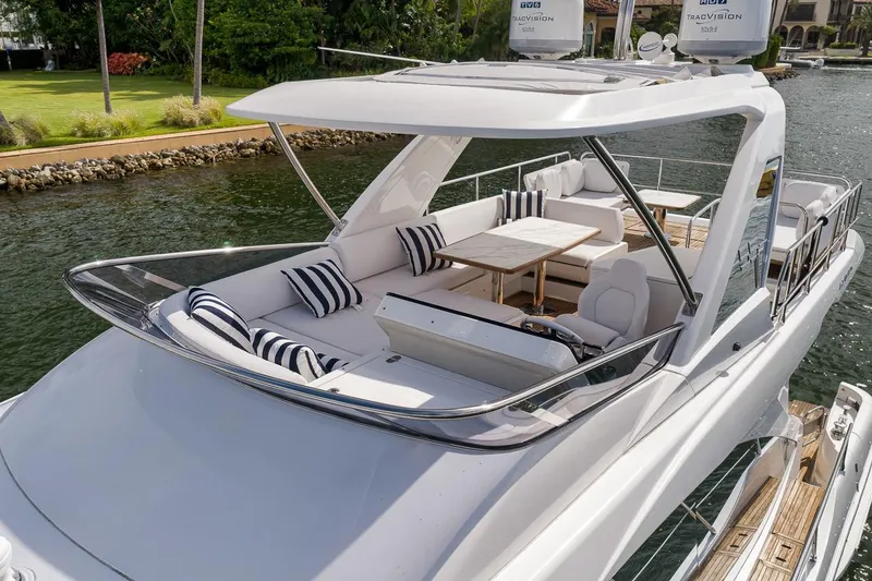 Slide: The Image of Luxurious 2019 Azimut 55 yacht with elegant seating and striped cushions on a sunny deck. - 34