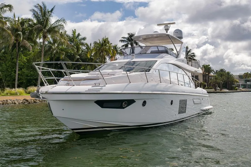 Slide: The Image of 2019 Azimut 55 yacht cruising near palm-lined shore under cloudy sky. - 37