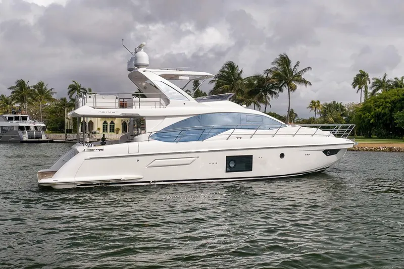 Slide: The Image of Luxury 2019 Azimut 55 yacht cruising near palm-lined shore under cloudy skies. - 42