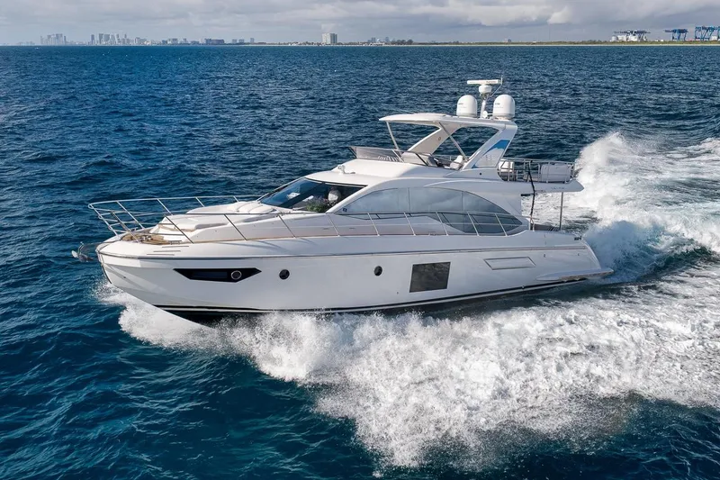 Slide: The Image of Luxurious 2019 Azimut 55 yacht cruising on open sea with city skyline in background. - 5