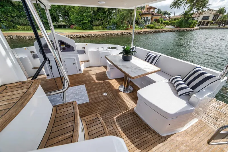 Slide: The Image of Luxurious 2019 Azimut 55 yacht deck with elegant seating and scenic waterfront view. - 73