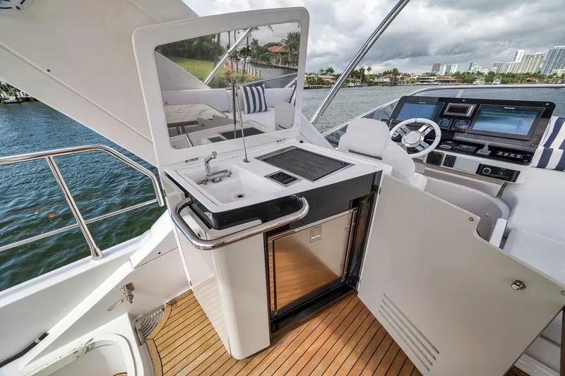 Slide: The Image of Luxurious 2019 Azimut 55 yacht cockpit with modern helm and kitchenette on open water. - 85