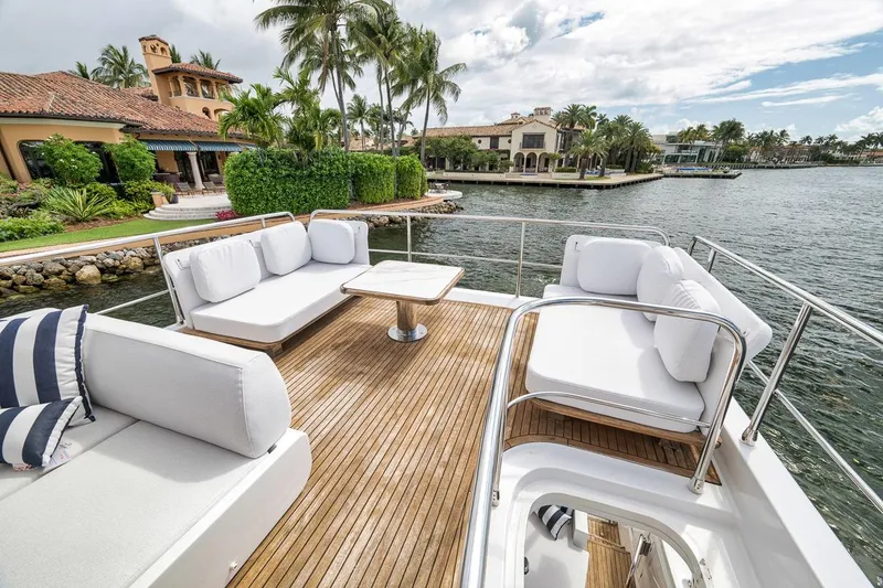 Slide: The Image of Luxurious 2019 Azimut 55 yacht deck with elegant seating, overlooking waterfront villas. - 87