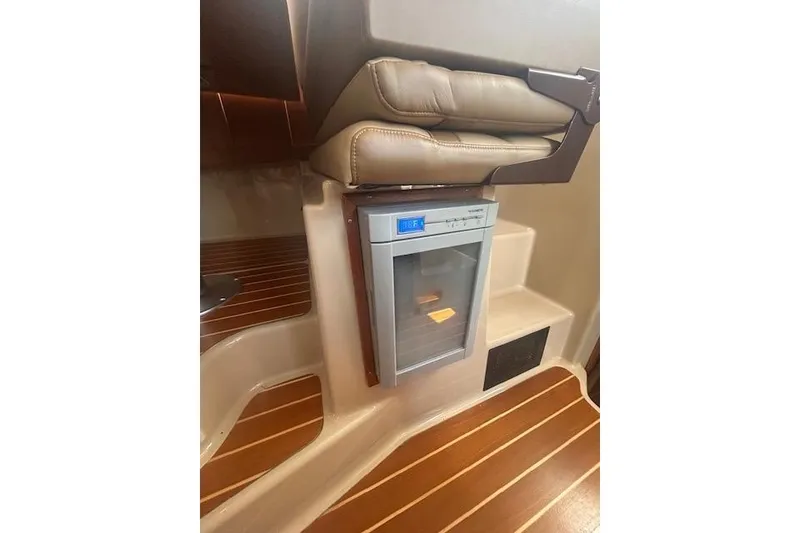 Slide: The Image of 2019 Ranger Tugs R-31-S interior with compact fridge and wooden flooring. - 22