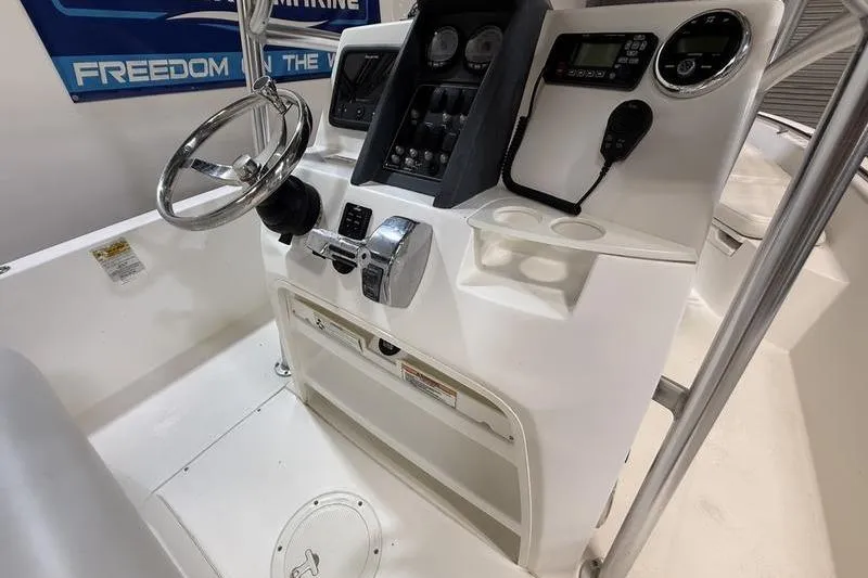 Slide: The Image of 2011 Boston Whaler 230 Dauntless boat console with steering wheel and control panel. - 10