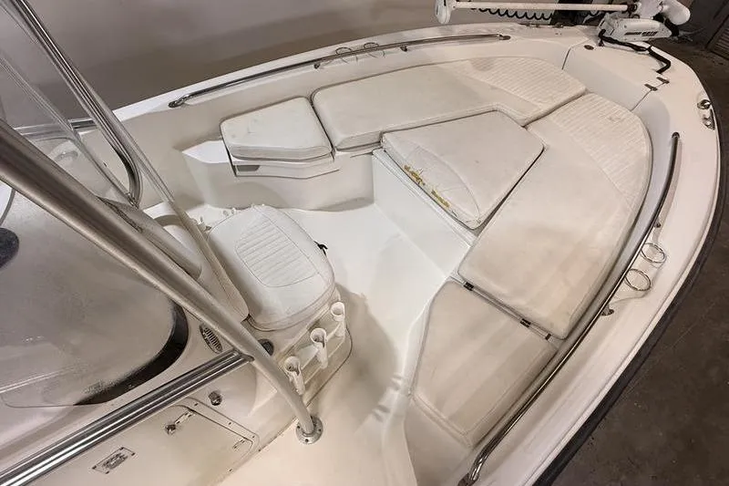 Slide: The Image of 2011 Boston Whaler 230 Dauntless boat interior with cushioned seating and stainless steel railings. - 15