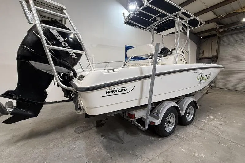 Slide: The Image of 2011 Boston Whaler 230 Dauntless boat on trailer in indoor storage. - 3