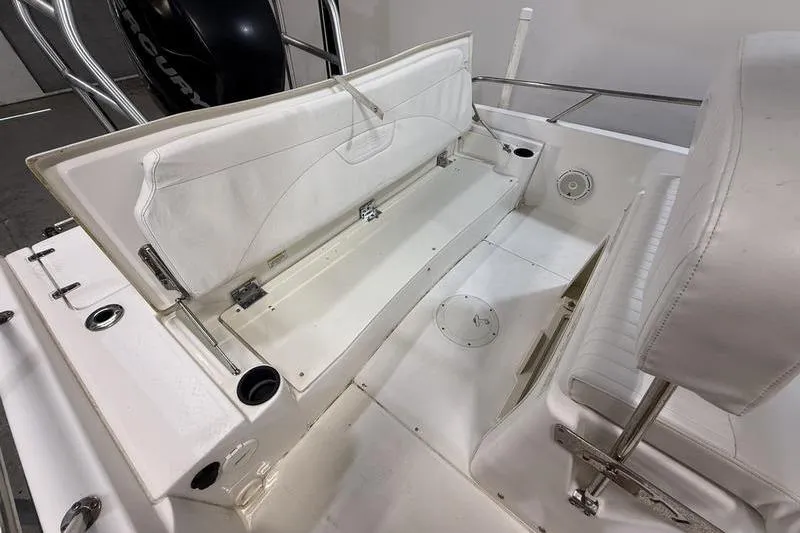 Slide: The Image of 2011 Boston Whaler 230 Dauntless boat interior with white seating and storage compartment. - 7