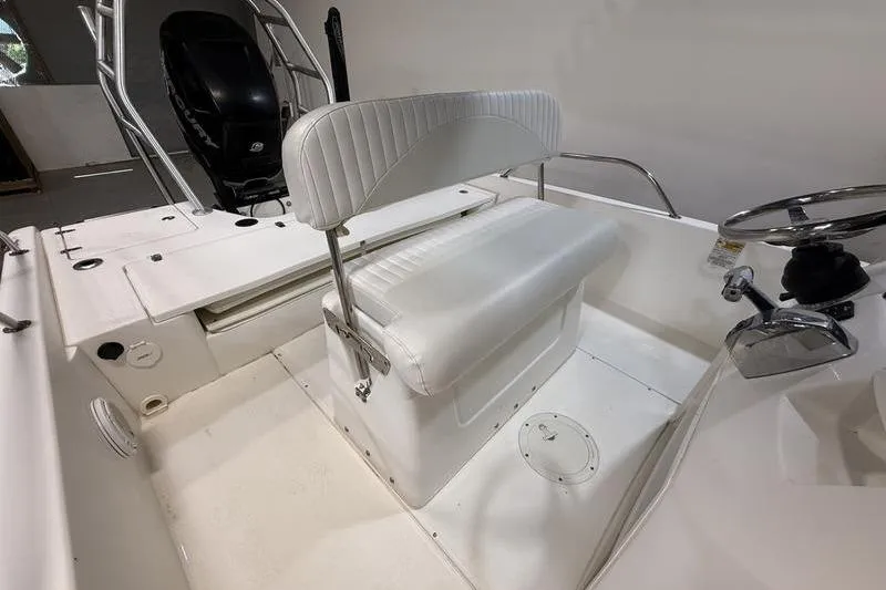 Slide: The Image of Interior of a 2011 Boston Whaler 230 Dauntless boat, featuring white seating and steering console. - 9