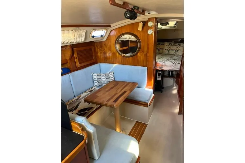 Slide: The Image of Interior of a 1988 Catalina 30 sailboat with cozy seating and wooden table. - 20