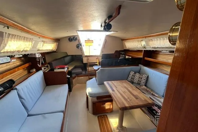 Slide: The Image of Interior of a 1988 Catalina 30 sailboat with cozy seating and wooden table. - 21