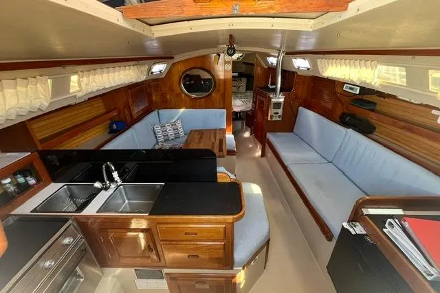 Slide: The Image of Interior of a 1988 Catalina 30 sailboat with cozy seating and wooden cabinetry. - 22