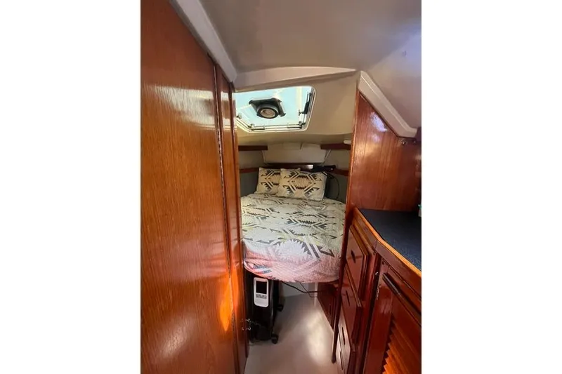 Slide: The Image of Interior cabin of a 1988 Catalina 30 sailboat with cozy bedding and wooden cabinetry. - 24