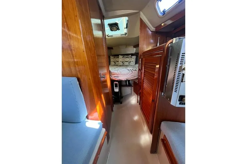 Slide: The Image of Interior of 1988 Catalina 30 sailboat with wooden finishes and cozy seating. - 25