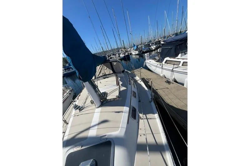 Slide: The Image of 1988 Catalina 30 sailboat docked in a marina, surrounded by other boats. - 4