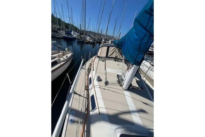 Slide: The Image of 1988 Catalina 30 sailboat docked in a marina, surrounded by other boats. - 6