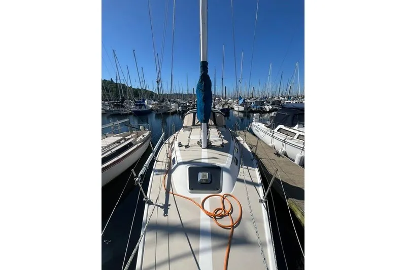 Slide: The Image of 1988 Catalina 30 sailboat docked in a marina under clear blue skies. - 8