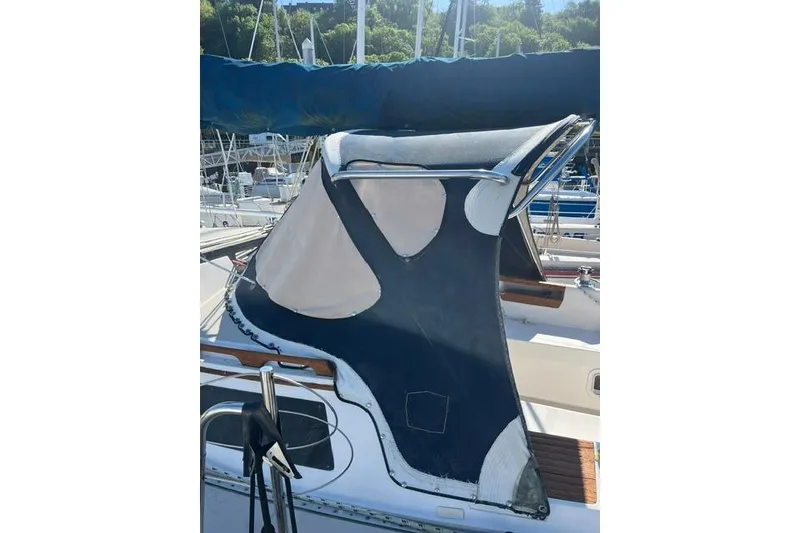 Slide: The Image of 1988 Catalina 30 sailboat with blue canvas cover in marina setting. - 9