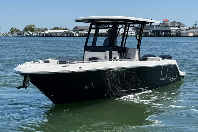 Slide: The Image of 2021 Robalo R272 Center Console boat on calm water, near a marina. - 10
