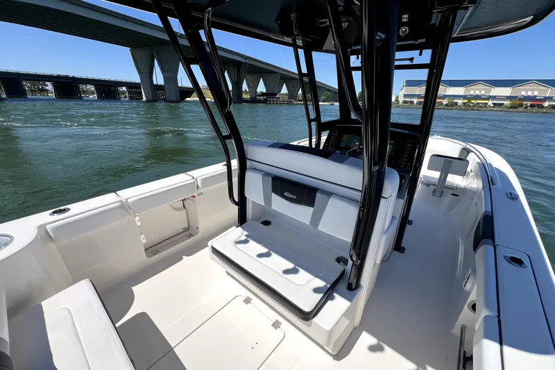 Slide: The Image of 2021 Robalo R272 Center Console boat on water near a bridge. - 12